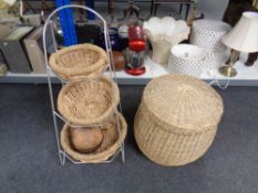 A wicker basket together with a three tier wicker storage stand.