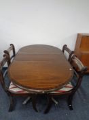 A Regency style extending dining table and four chairs.