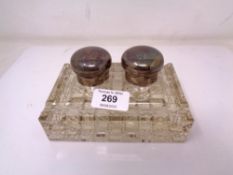 An early 20th century glass inkwell with silver mounts