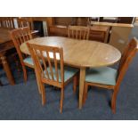 A contemporary rubberwood extending oval dining table and a set of four chairs