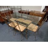 A contemporary glass and metal framed dining table with a set of six chairs