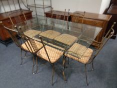 A contemporary glass and metal framed dining table with a set of six chairs