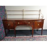 A Regency mahogany and satinwood inlaid bow fronted serving table with brass rail back fitted a