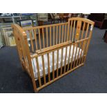 A cot with mattress and a stair gate