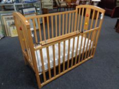 A cot with mattress and a stair gate