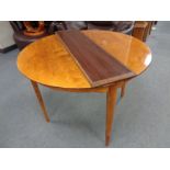 A continental satinwood circular dining table with leaf