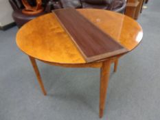 A continental satinwood circular dining table with leaf