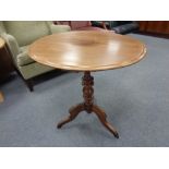 A circular mahogany tripod wine table