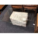 A contemporary rectangular glass topped coffee table on stone effect support