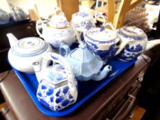 A tray containing seven antique and later ceramic teapots and lidded sugar basins
