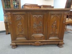 A continental beech sideboard with carved panel doors