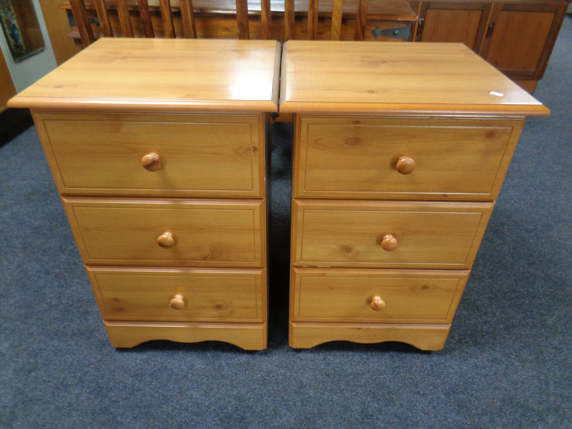 A pair of pine effect three drawer bedside chests