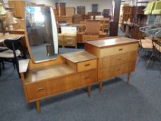 A 20th century teak three drawer chest with a similar mirror back low dressing table