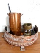 An antique D-shaped copper embossed fire fender on paw feet with a copper twin handled pot,