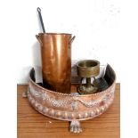 An antique D-shaped copper embossed fire fender on paw feet with a copper twin handled pot,