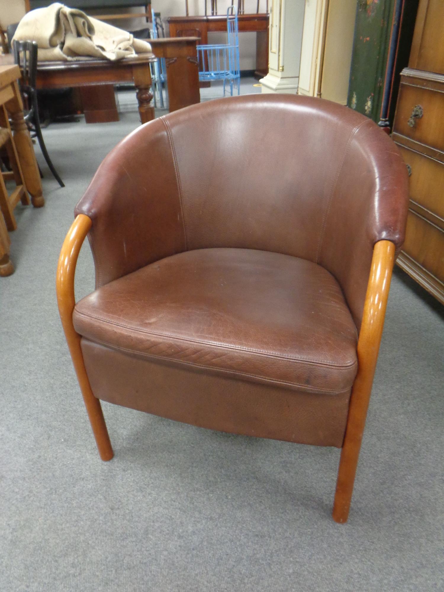 A tub chair upholstered in maroon leather