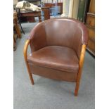 A tub chair upholstered in maroon leather