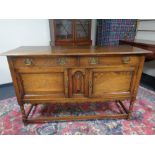 An oak sideboard fitted with cupboards and drawers beneath