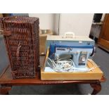 A wicker picnic hamper and a cased New Home electric sewing machine