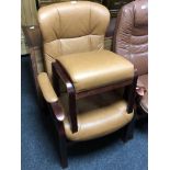 A tan leather upholstered armchair and matching footstool