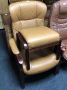 A tan leather upholstered armchair and matching footstool