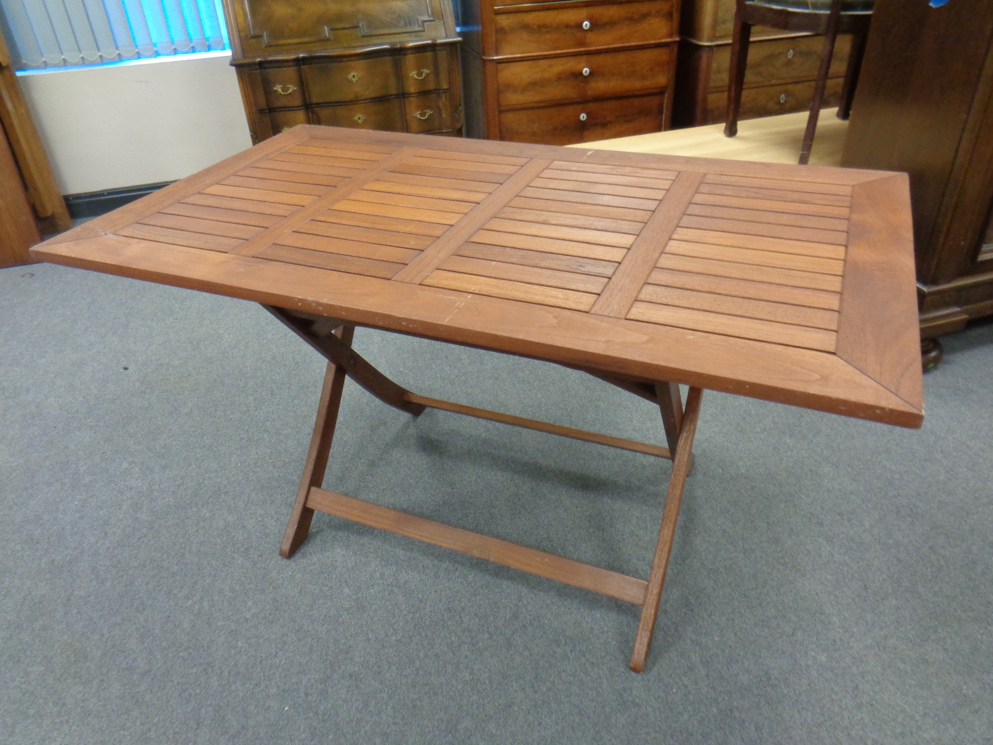 A large stained teak rectangular garden table