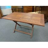 A large stained teak rectangular garden table