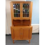 A continental teak and leaded glass corner cabinet
