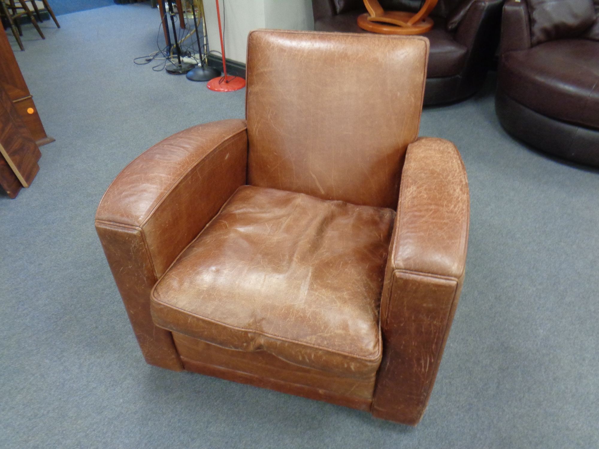 A brown leather upholstered club armchair