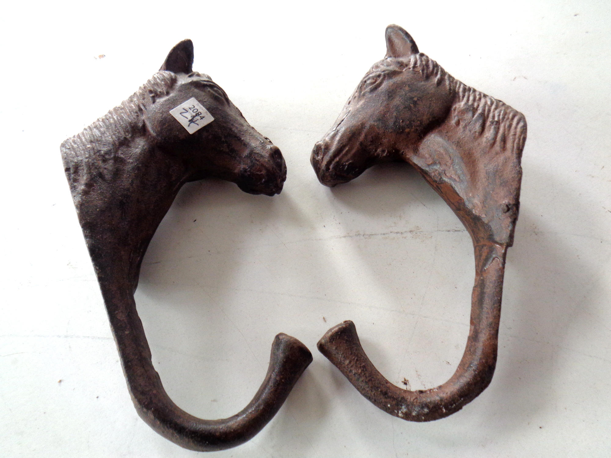 Two cast iron horse coat hooks