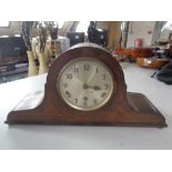 An inlaid oak mantel clock with silvered dial