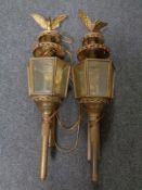 A pair of brass coach lamps with brackets surmounted by an eagle (electrified)