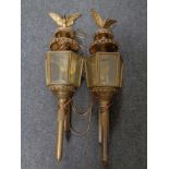 A pair of brass coach lamps with brackets surmounted by an eagle (electrified)