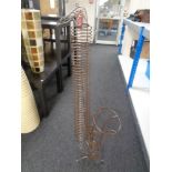A wire metal CD stand in the form of a saxophone