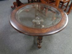 A contemporary circular glass topped coffee table on four way gilt support