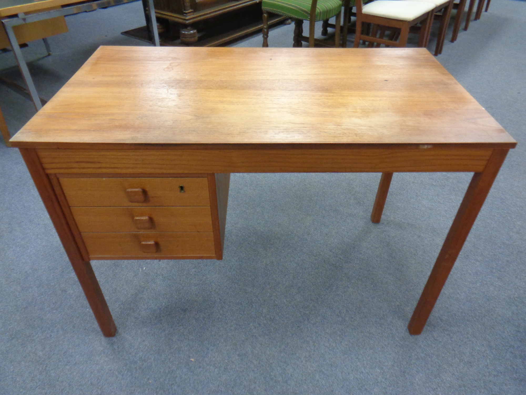 A 20th century continental teak writing desk fitted with three drawers