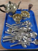 A tray of three piece silver plated tea set and unboxed stainless steel cutlery