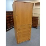 An oak single door office cabinet fitted with drawers beneath