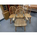 A set of four beech spindle-back dining chairs comprising one carver and three singles