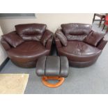 A pair of Burgundy leather swivel cuddle chairs with cushions together with a further leather