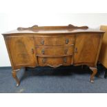 A walnut serpentine front sideboard fitted with cupboards and drawers with a matching extending