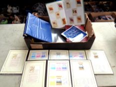 A box containing an album of cigarette cards, modern postcards,