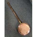 A copper beech handled bed warming pan