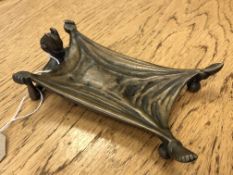 An antique brass calling card tray in the form of The Devil Under an Outstretched Blanket,