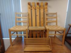 A pine coat rack with a pair of chairs,