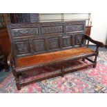 An 18th century carved oak settle