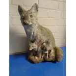 A concrete garden fox and cub figure