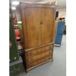 A 20th century walnut veneered two door cabinet with three drawers fitted beneath