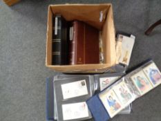 A box containing loose 20th century world stamps and albums containing First Day Covers