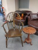 A beech wheel back armchair with a carved circular tripod table